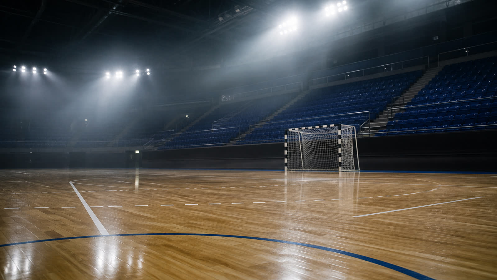 Tom handbollshall med belyst plan och tomma läktare — atmosfär inför Handbollsligan