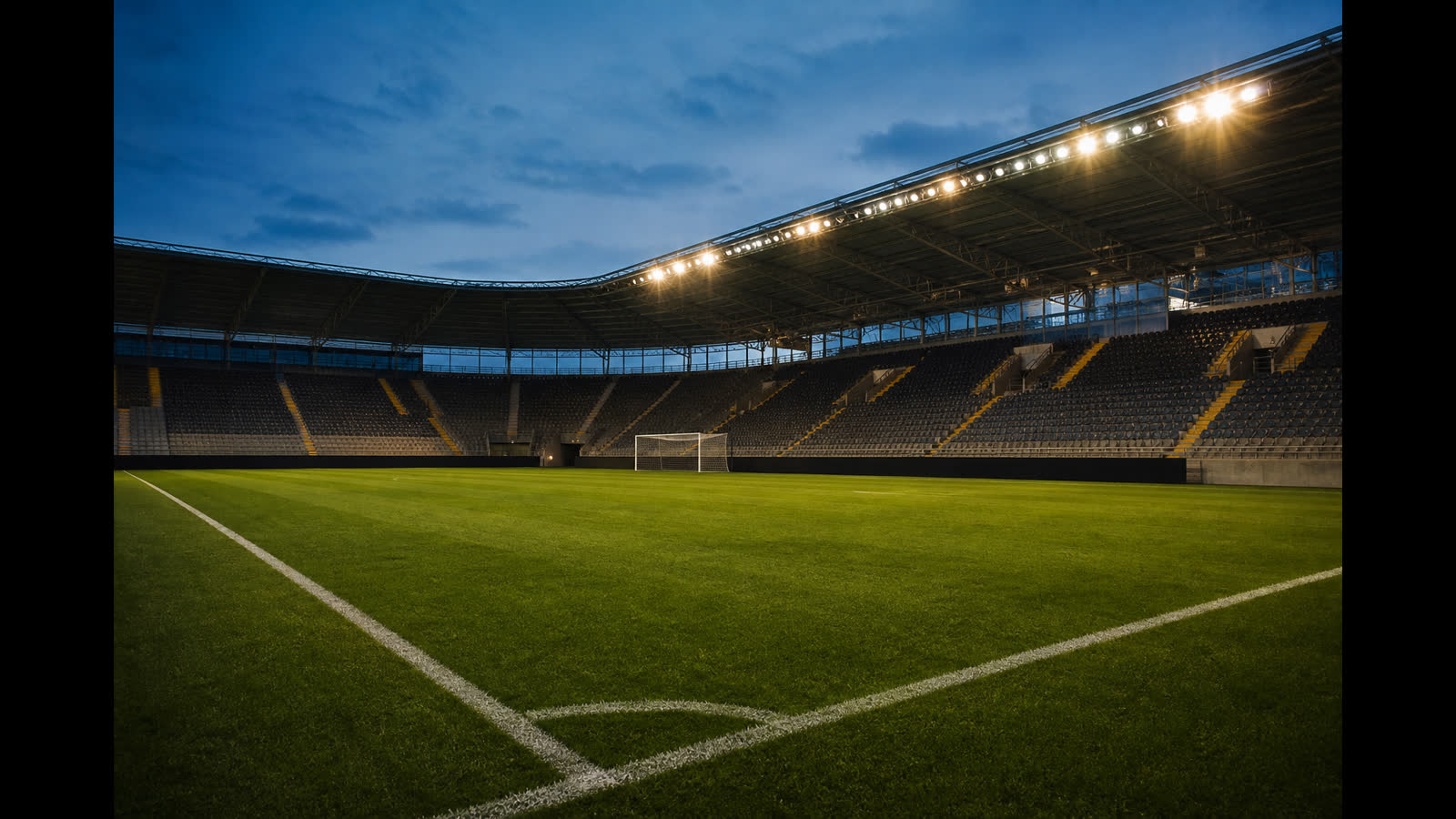 Tom fotbollsarena i skymning med belyst plan och tomma läktare — atmosfär inför Svenska cupen